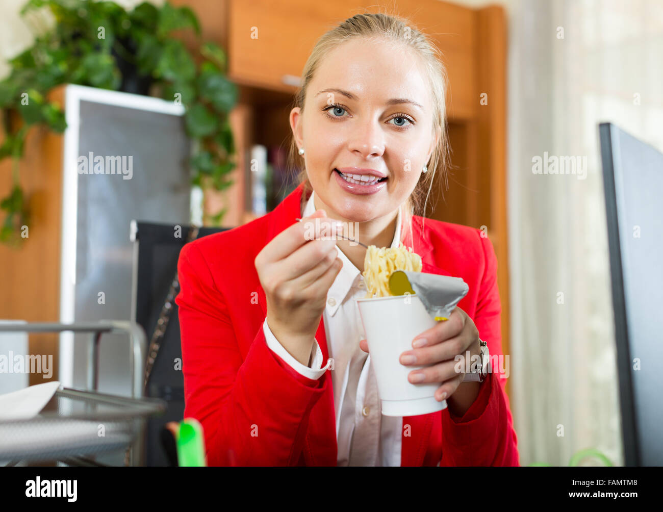 Lavoratore di sesso femminile avente a cottura rapida tagliatelle all'area di lavoro Foto Stock