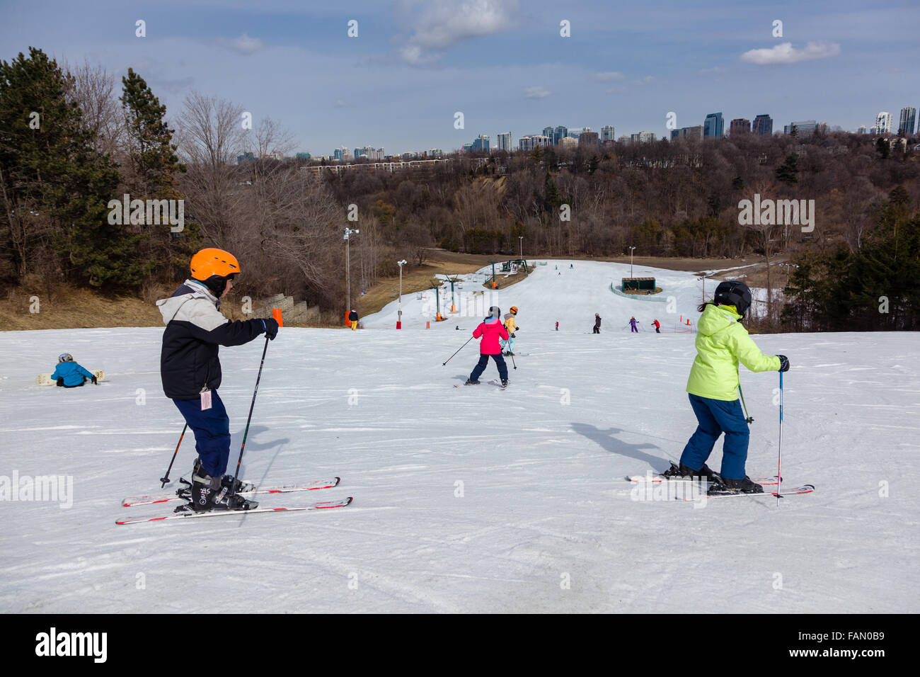 Gli sciatori e gli snowboarder in cima di una collina di sci a Toronto. Foto Stock