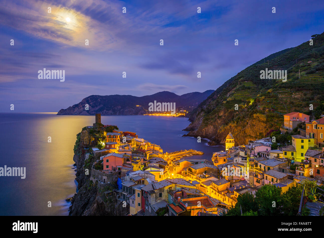 Pre alba vista di Vernazza porto e la torre dalla chiesa di Santa Margherita d'Antiochia con città di Monorossa vista in distanza, Foto Stock