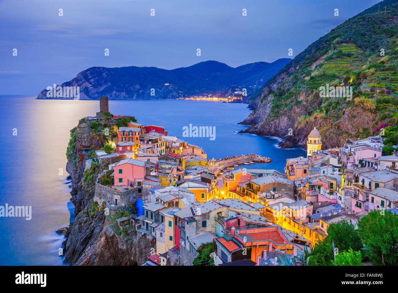 Pre alba luna illuminata vista di Vernazza harbor, Castello Doria e vista di Monorossa in distanza, Italia Foto Stock