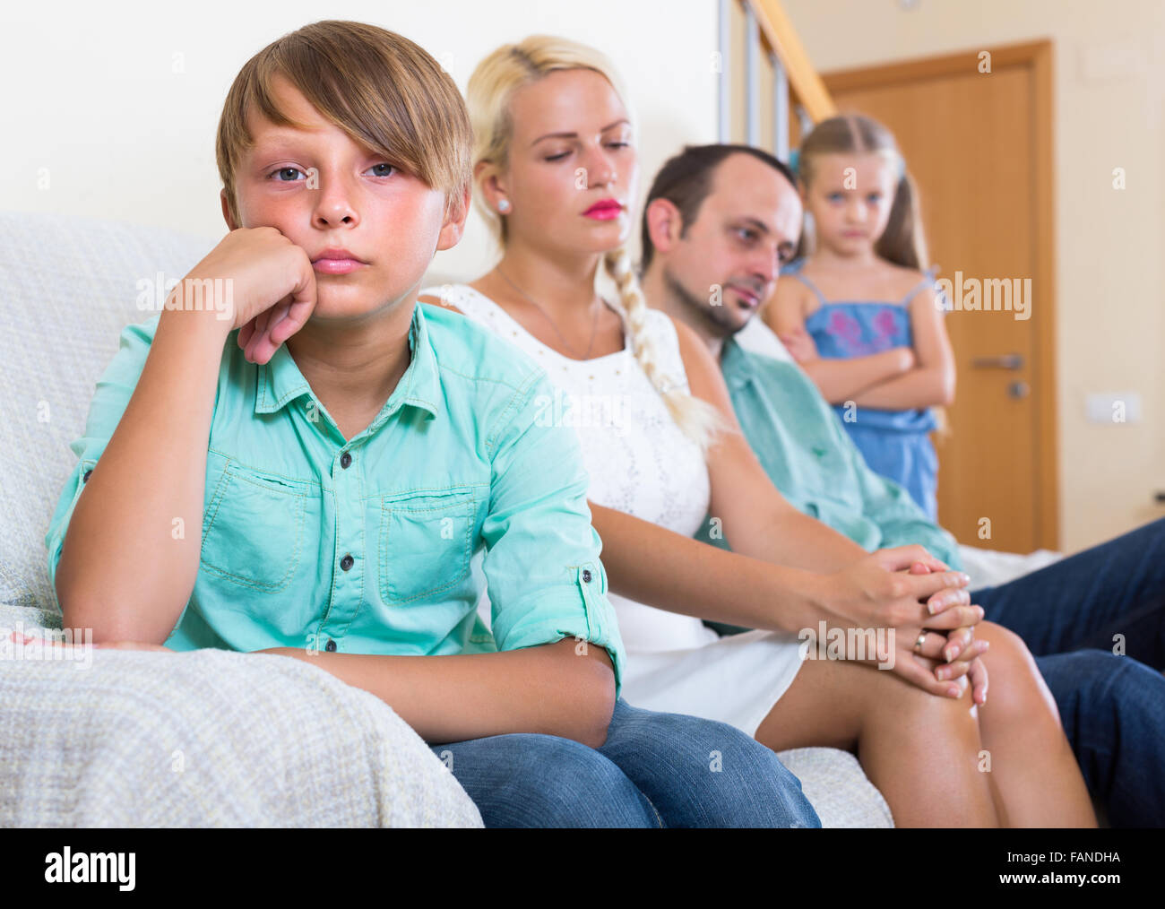 Triste stanchi genitori e due bambini a bad conflitto a casa Foto Stock