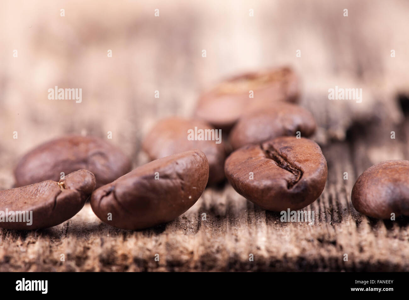 I chicchi di caffè sulla ruvida la superficie di legno closeup Foto Stock