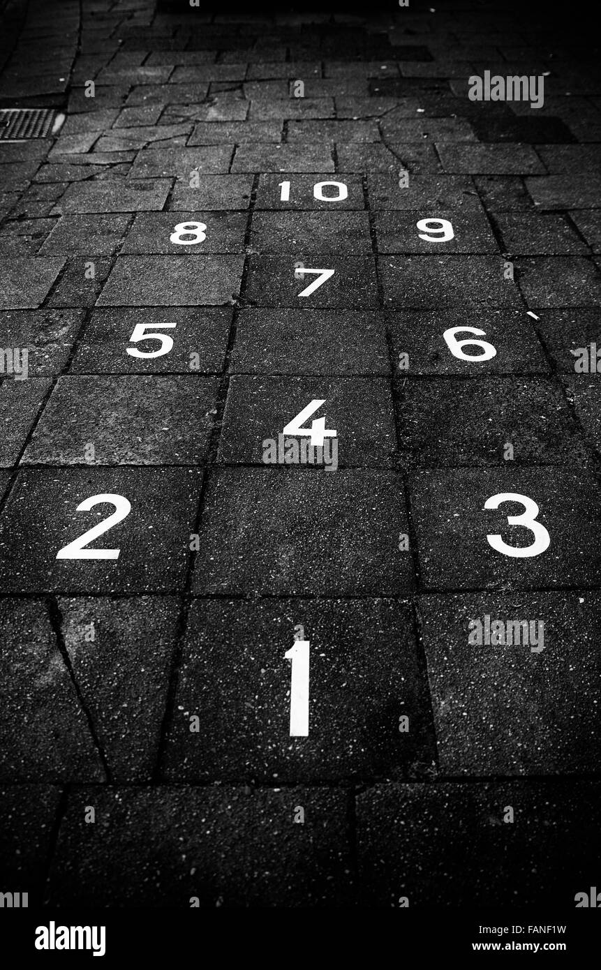 Campana gioco su un marciapiede Foto Stock