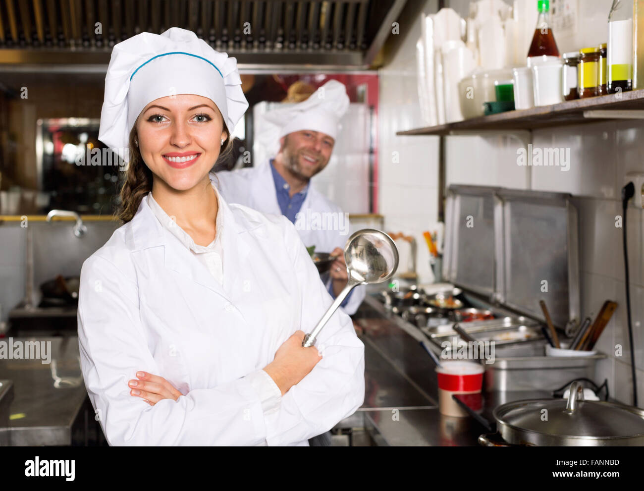 Sorridente chef professionisti che lavorano in ristorante cucina Foto Stock