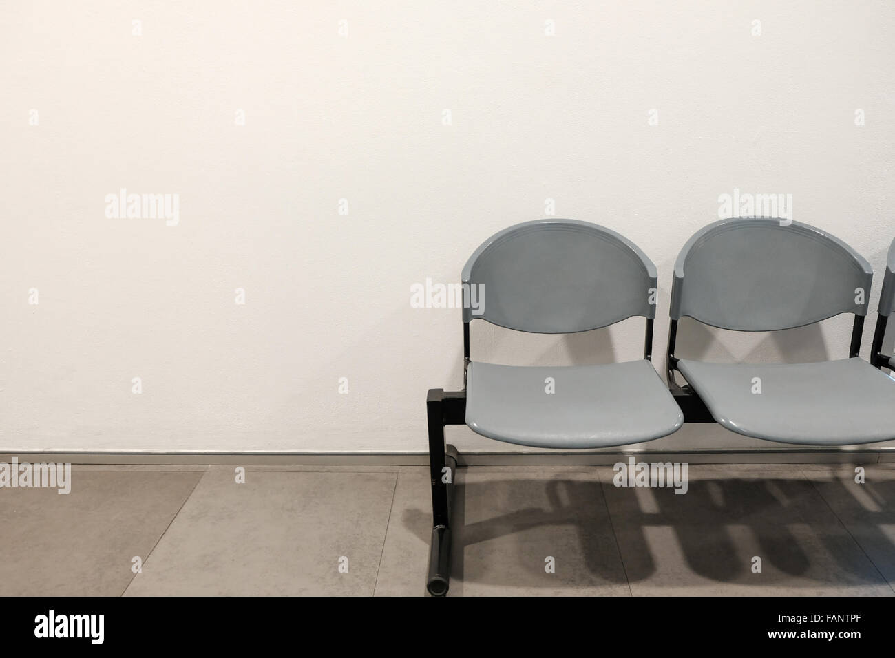 Due sedie vuote da parete in calcestruzzo con copyspace Foto Stock
