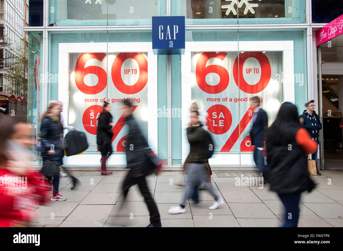 Persone di passaggio segni di vendita in oxford street. Foto Stock