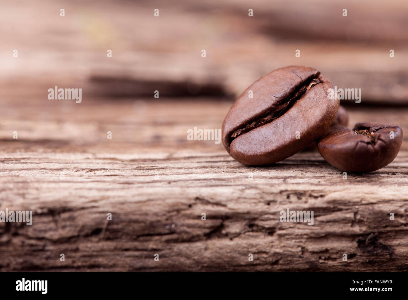 I chicchi di caffè sulla ruvida la superficie di legno closeup Foto Stock