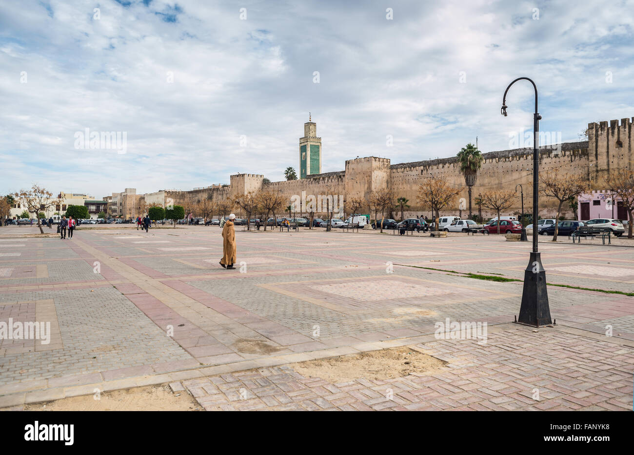 Persone che camminano in luogo Lalla Loudain nella medina il whit la grande moschea torre di Meknes e parete della città in background. Il Marocco. Foto Stock