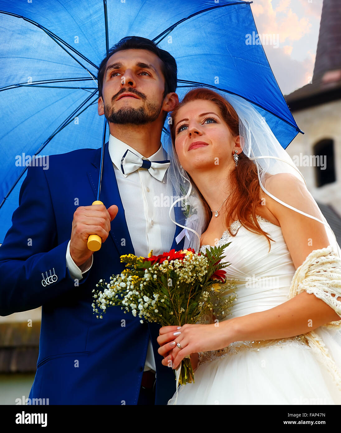 La sposa e lo sposo con ombrello blu in una chiesa storica Foto stock -  Alamy