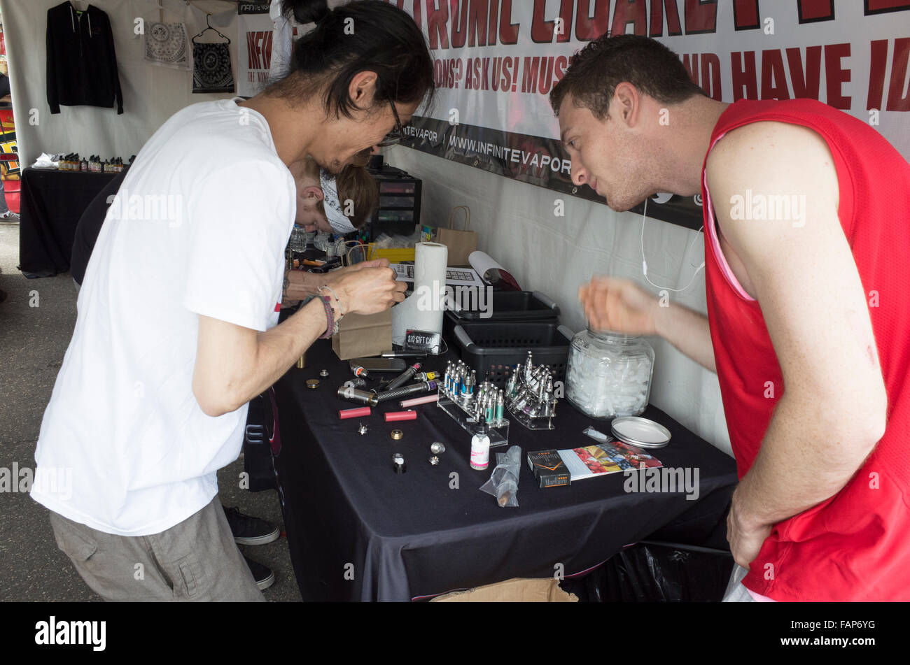 Tre uomini il caricamento e-cigs al vapore infinito stand di concessione. Grand Old giorno Street Fair. St Paul Minnesota MN USA Foto Stock