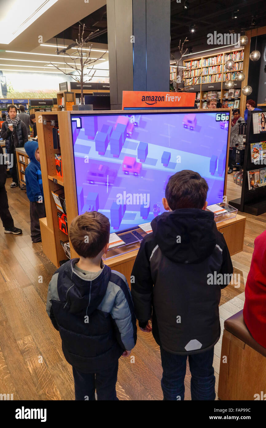 I ragazzi di guardare video game on Fire tv, libri di mattoni e malta negozio, Village Universitario, Seattle, nello Stato di Washington, USA Foto Stock