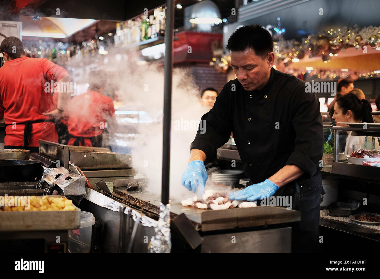 Lo chef cucinare pesce in Cafe Boqueria nel Mercato di Boqueria, Barcellona Foto Stock