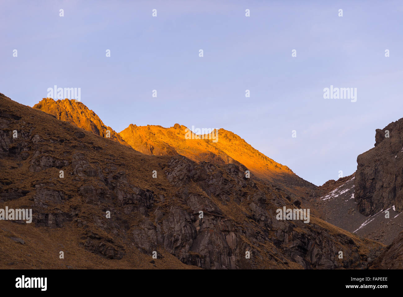 Ultima luce calda del sole sulla montagna rocciosa cime delle Alpi. Terreni estremi del paesaggio ad alta altitudine nel Parco Nazionale, Italia. Foto Stock