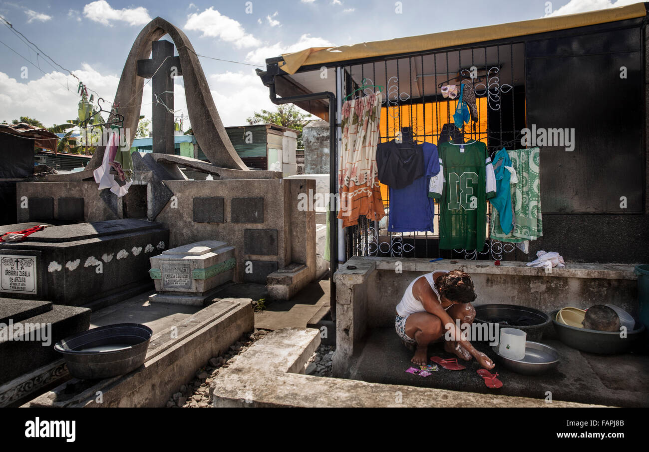 Una donna il lavaggio di se stessa in un cimitero a Manila nelle Filippine Foto Stock