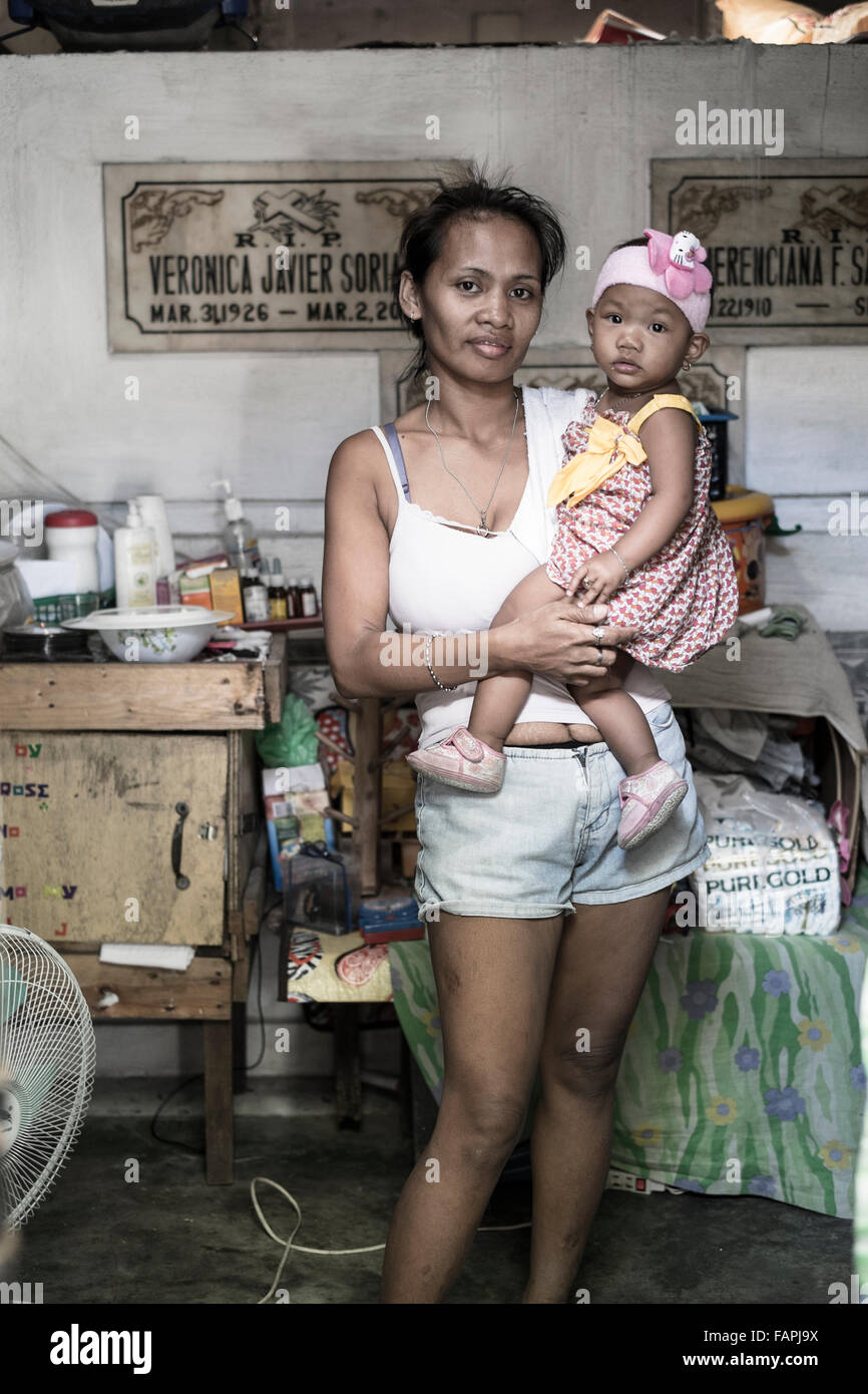 Una madre e figlia in posa in un cimitero di Manila Foto Stock