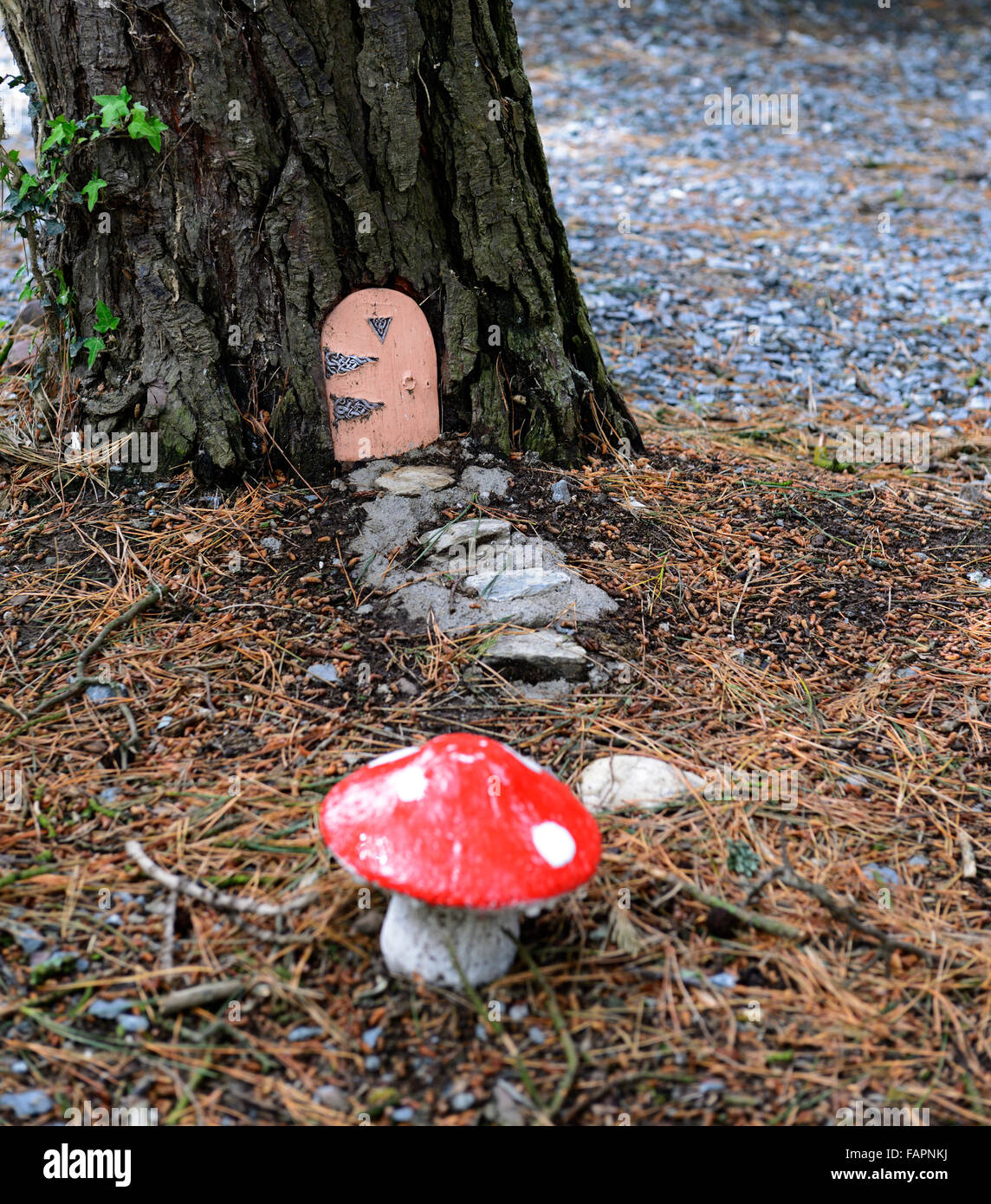 Fairy casa porta base albero giardino decorazione decorare la nana in miniatura il divertimento all'aperto fantasy fare credere toadstool rosso floreale RM Foto Stock