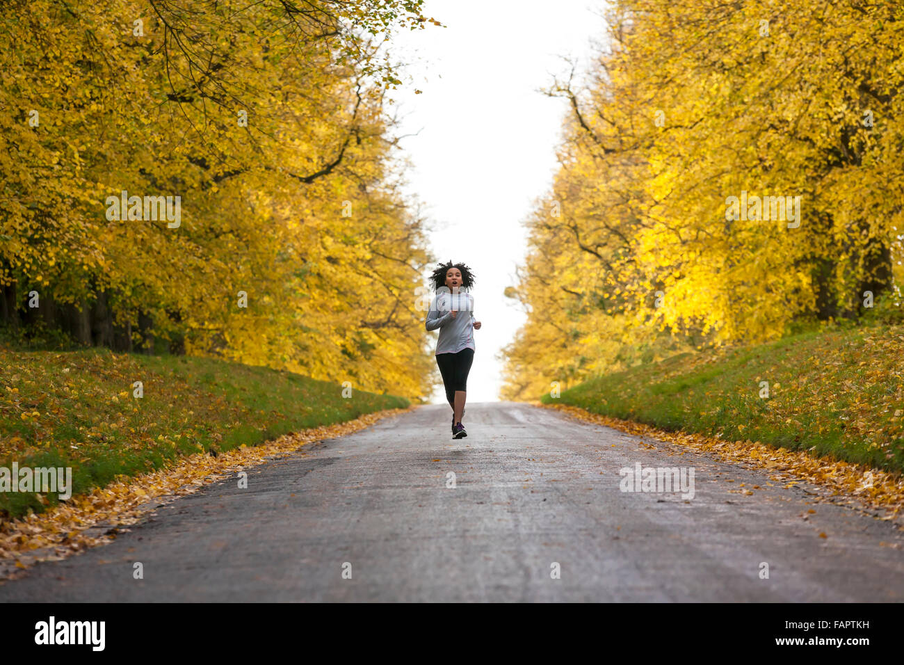 Bellissima gara di misto americano africano donna giovane ragazza adolescente in esecuzione fitness jogging in autunno cadono alberi Foto Stock