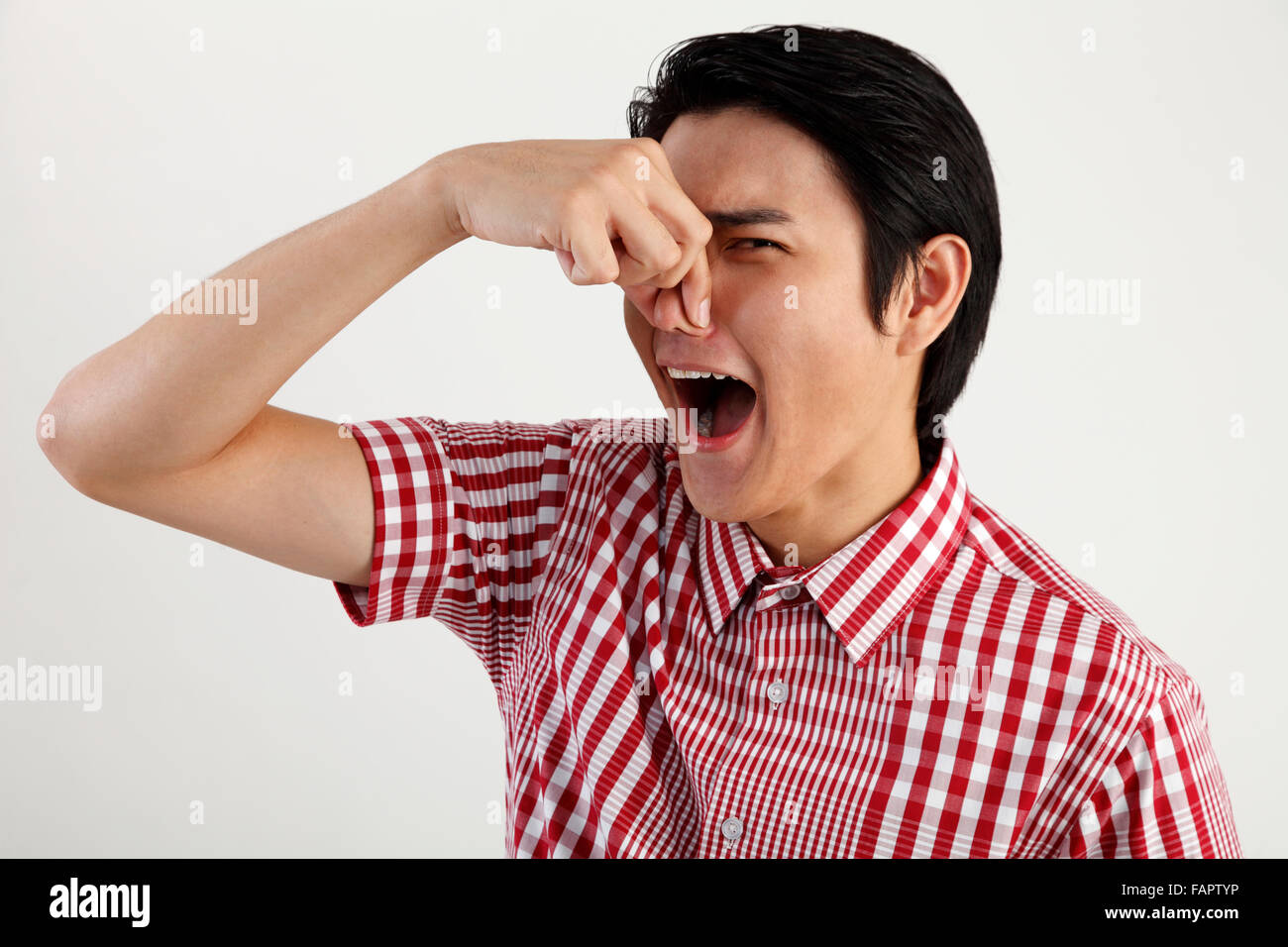 Giovane uomo premendo il suo naso Foto Stock
