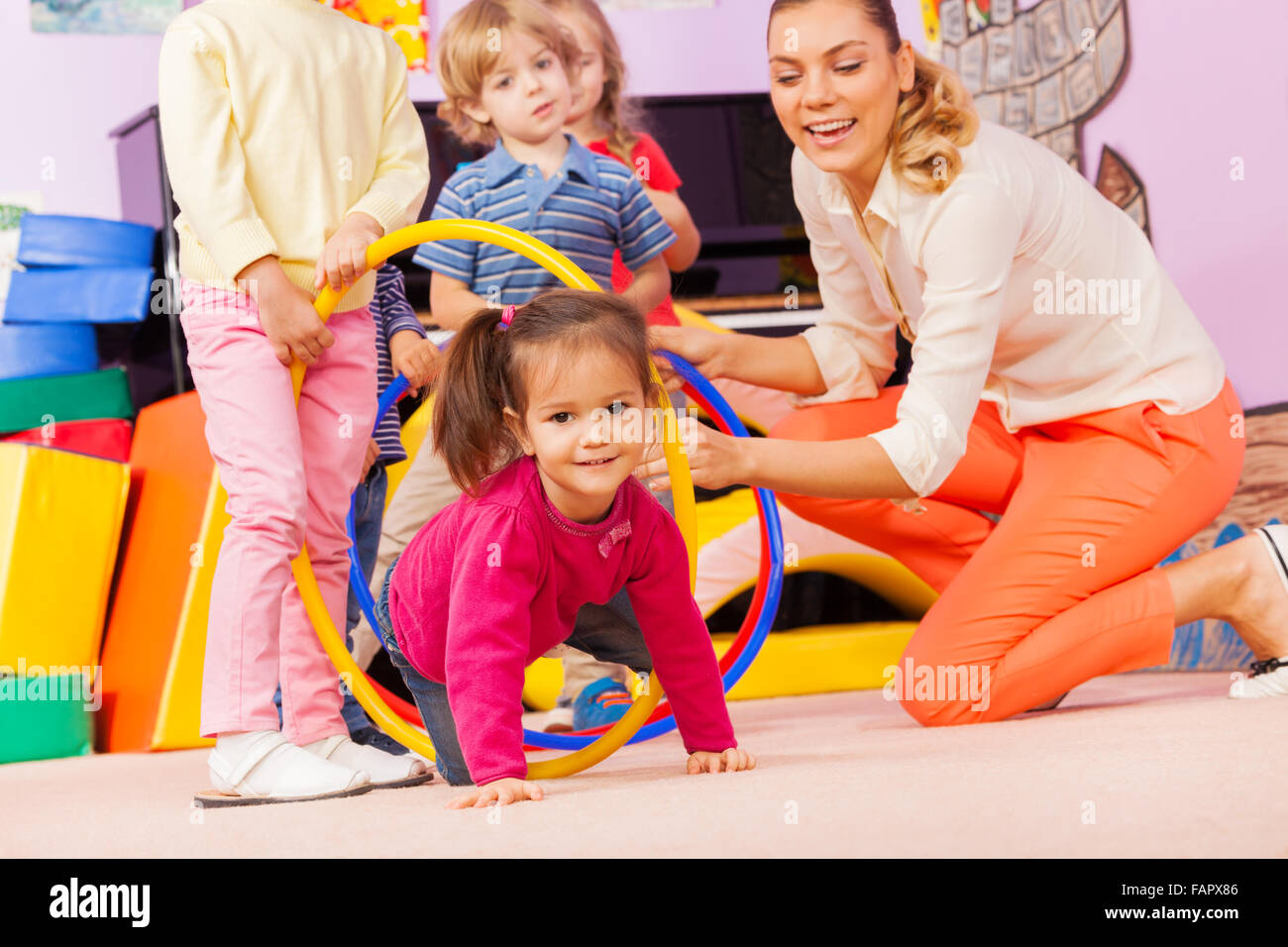 I bambini con la ragazza e insegnante giocare gioco attivo Foto Stock