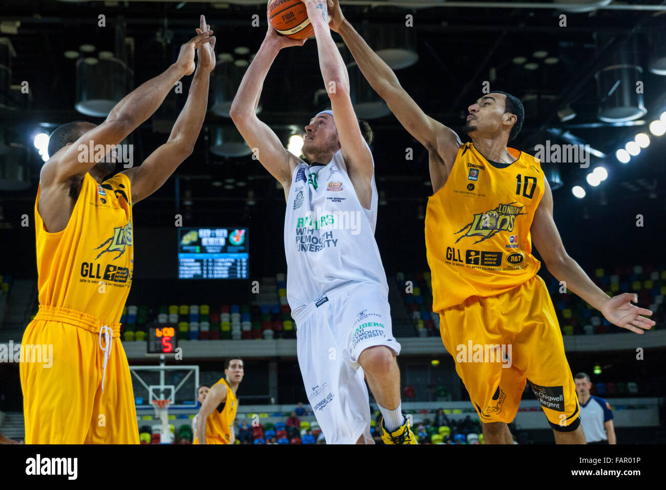 Londra, Regno Unito. Il 3° gennaio 2016. Plymouth Raiders' Adrien Sturt (20) salta in alto con la palla mentre Zach Gachette (10) e Demond Watt (21) da Lions di provare a bloccare il suo tiro durante il London Lions vs. Plymouth Raiders BBL gioco presso la casella di rame Arena del Parco Olimpico. London Lions vincere 86-84 Credito: Imageplotter/Alamy Live News Foto Stock