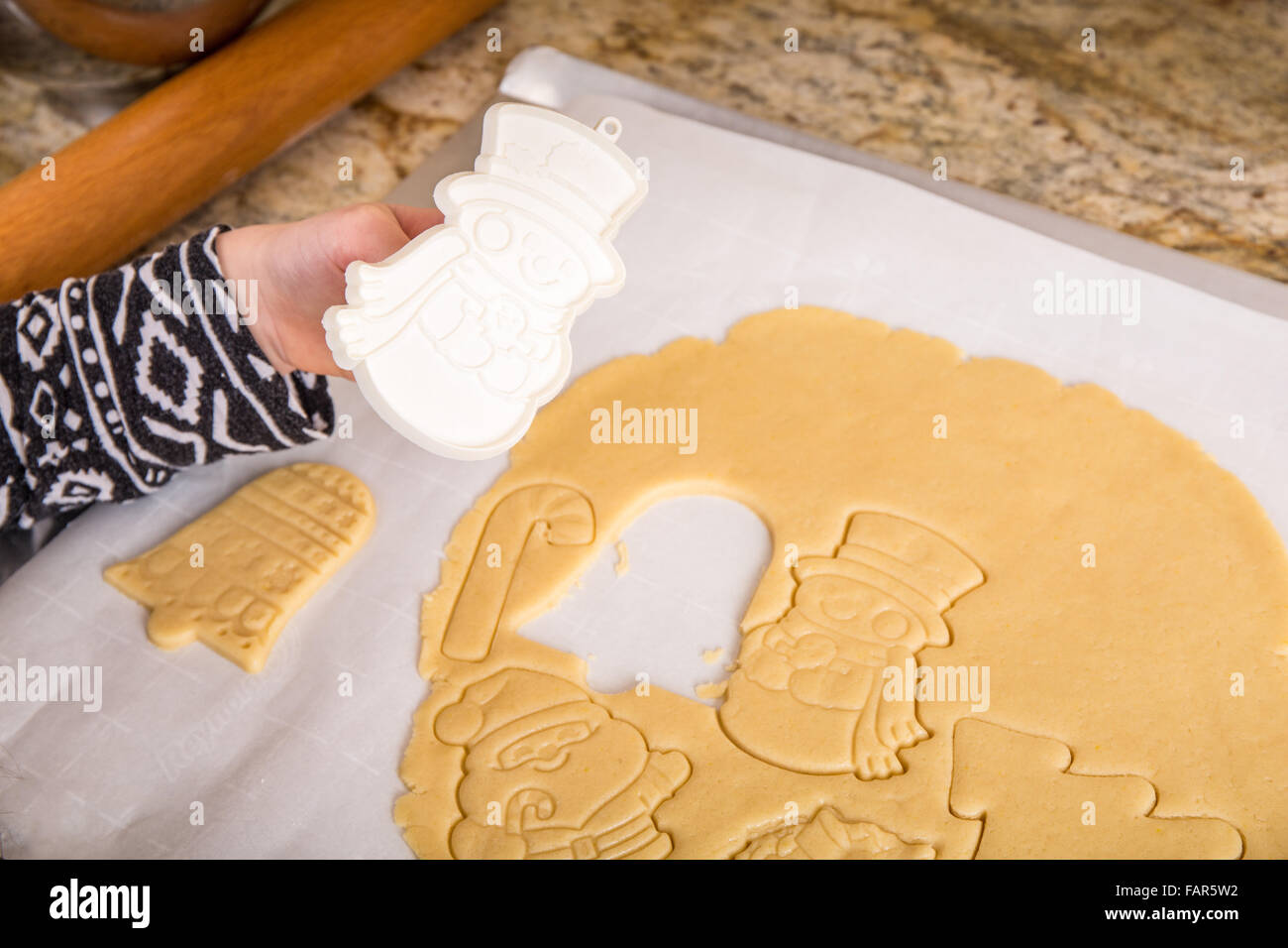 Dieci anni di ragazza utilizzando cookie cutter per tagliare lo zucchero di Natale i cookie in Issaquah, Washington, Stati Uniti d'America Foto Stock