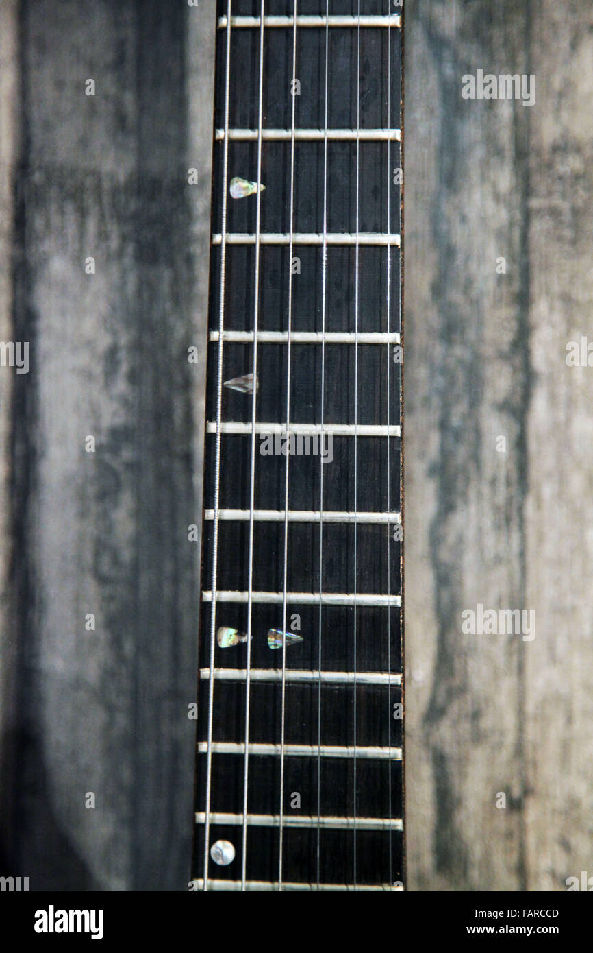 Si tratta di una foto di una musica di chitarra che lo strumento è agganciato ad una parete in legno Foto Stock