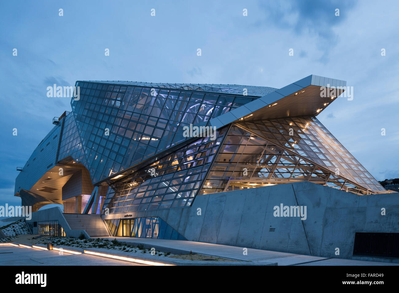 Crepuscolo elevazione con zoccolo e illuminazione di interni. Il Musée des Confluences, Lione, Francia. Architetto: COOP HIMMELB(L)AU, 2014. Foto Stock