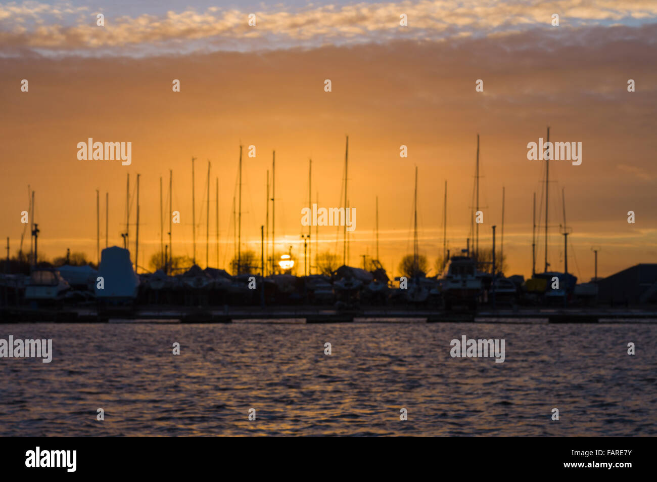 Immagine sfocata del tramonto nel porto di yacht con sagome del montante Foto Stock