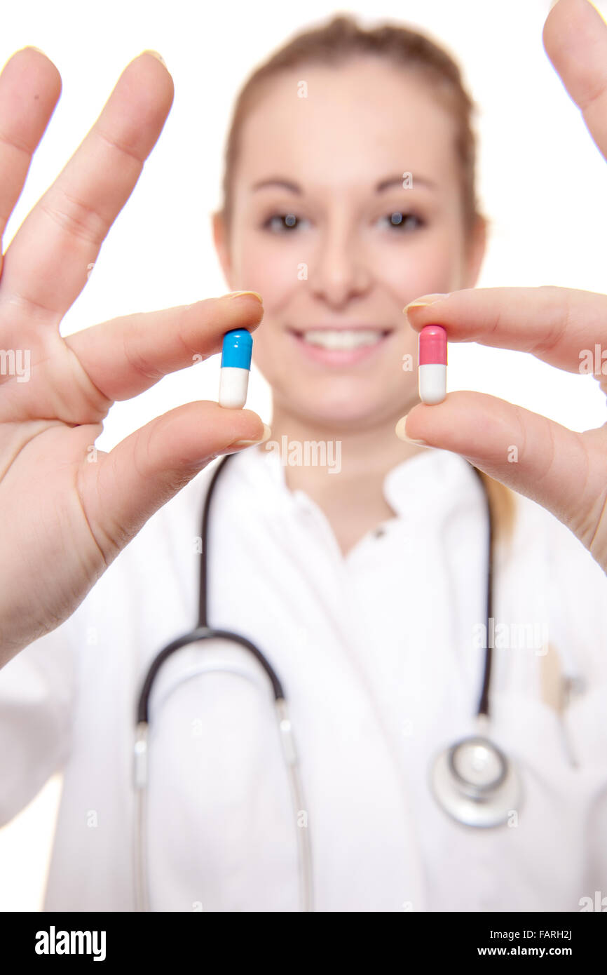Femmina attraente medico tenendo due pillole. Tutto su sfondo bianco. Foto Stock