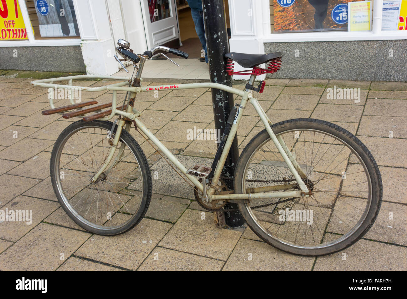 Un vecchio stile "commercio" bicicletta dotata di un rack anteriore per il trasporto di un cestello consegna equipaggiato con asta di freni Foto Stock
