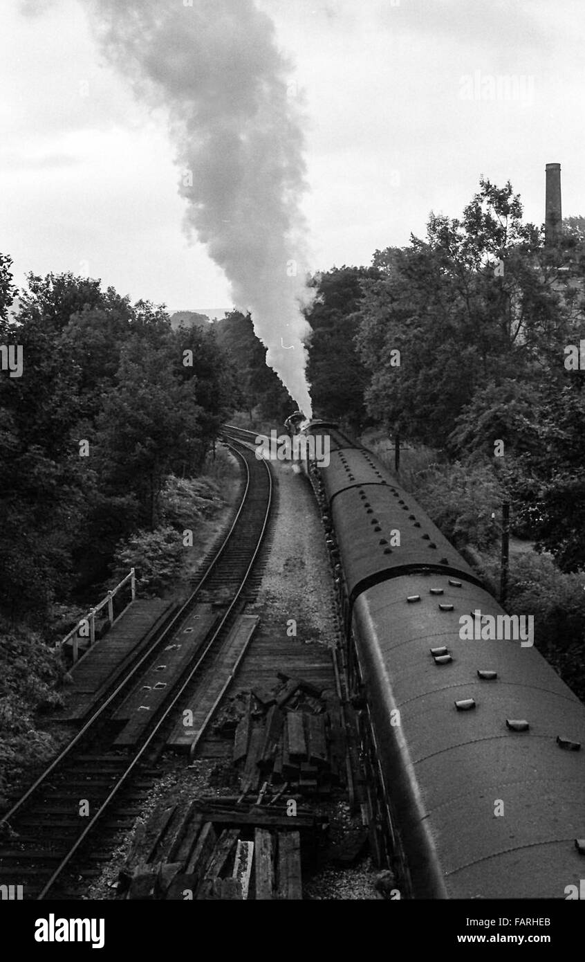 Haworth stazione ferroviaria, West Yorkshire circa 1982 in bianco e nero delle immagini di archivio. Home di Keighley e Worth Valley Railway, il KWVR è presidiata da volontari. Padiglione delle Carrozze del treno a vapore che passa sotto un ponte. Foto Stock