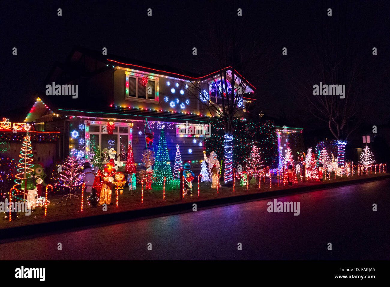 Visualizzazione delle luci di Natale e i personaggi dei cartoni animati in casa nella maggiore di Vancouver. Vacanza Outdoor display luminoso, residenziale. Foto Stock