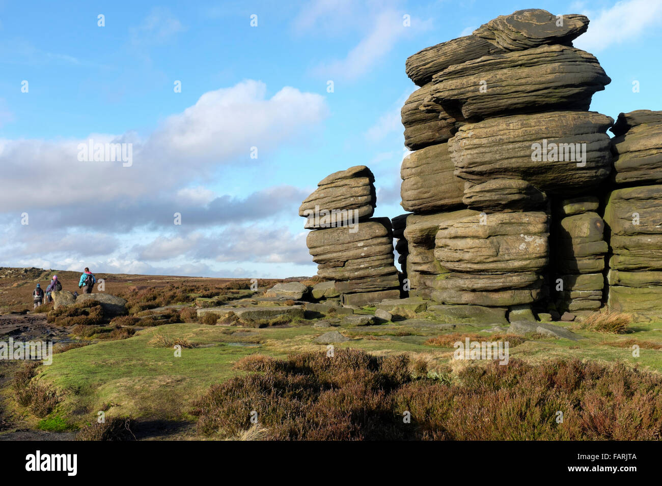 Un gruppo di escursionisti che passano la ruota pietre, Derwent Edge, Derwent Moor, Derbyshire, England, Regno Unito Foto Stock