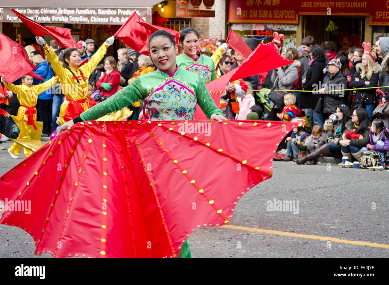 Giovani donne asiatiche di eseguire con grande fan di rosso durante il Nuovo Anno Cinese's Parade in Vancouver Chinatown, 2015. Foto Stock