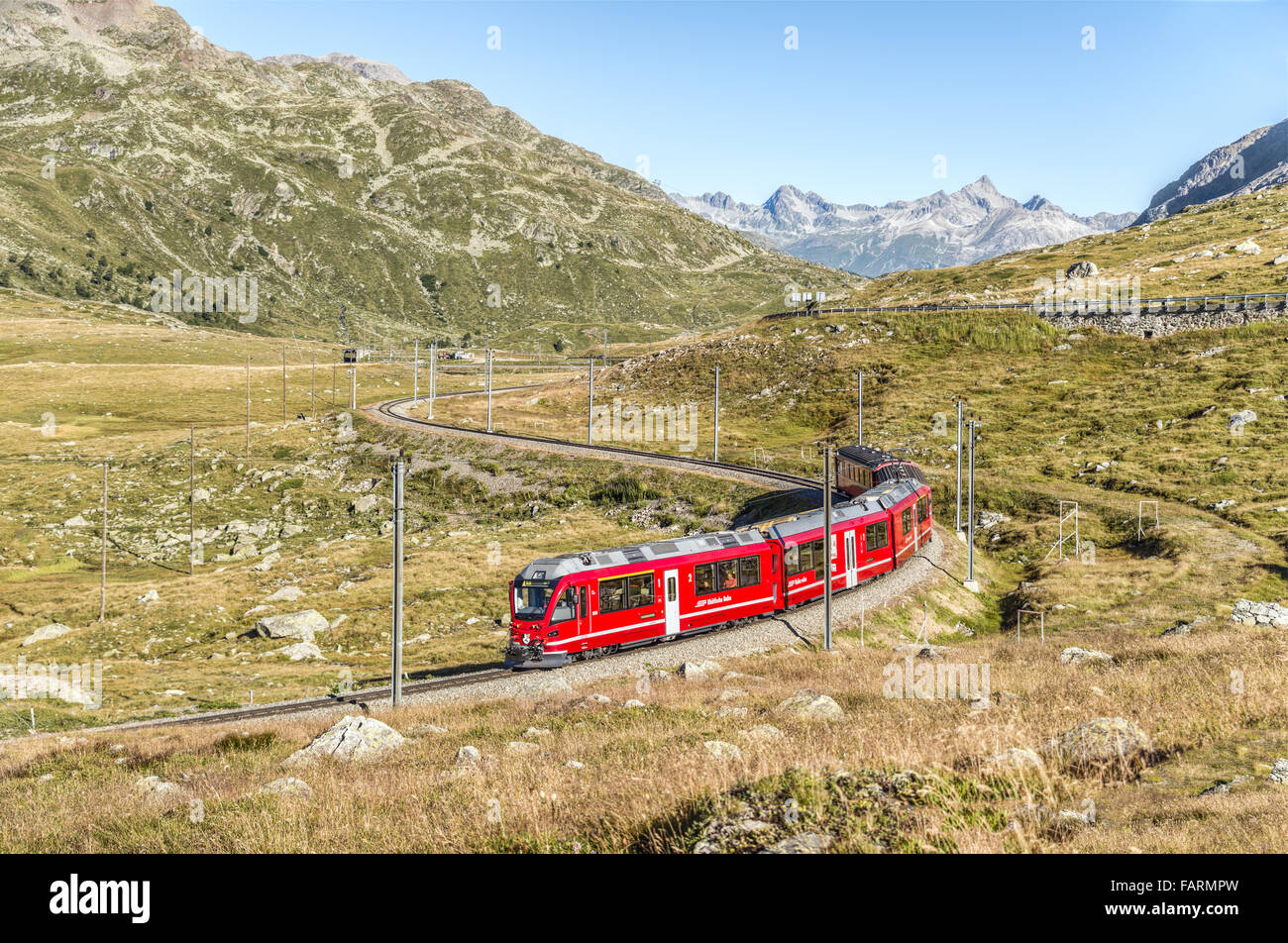 Treno alpino in un paesaggio montano al Lago Bianco, Passo Bernina, Grigioni, Svizzera in estate Foto Stock