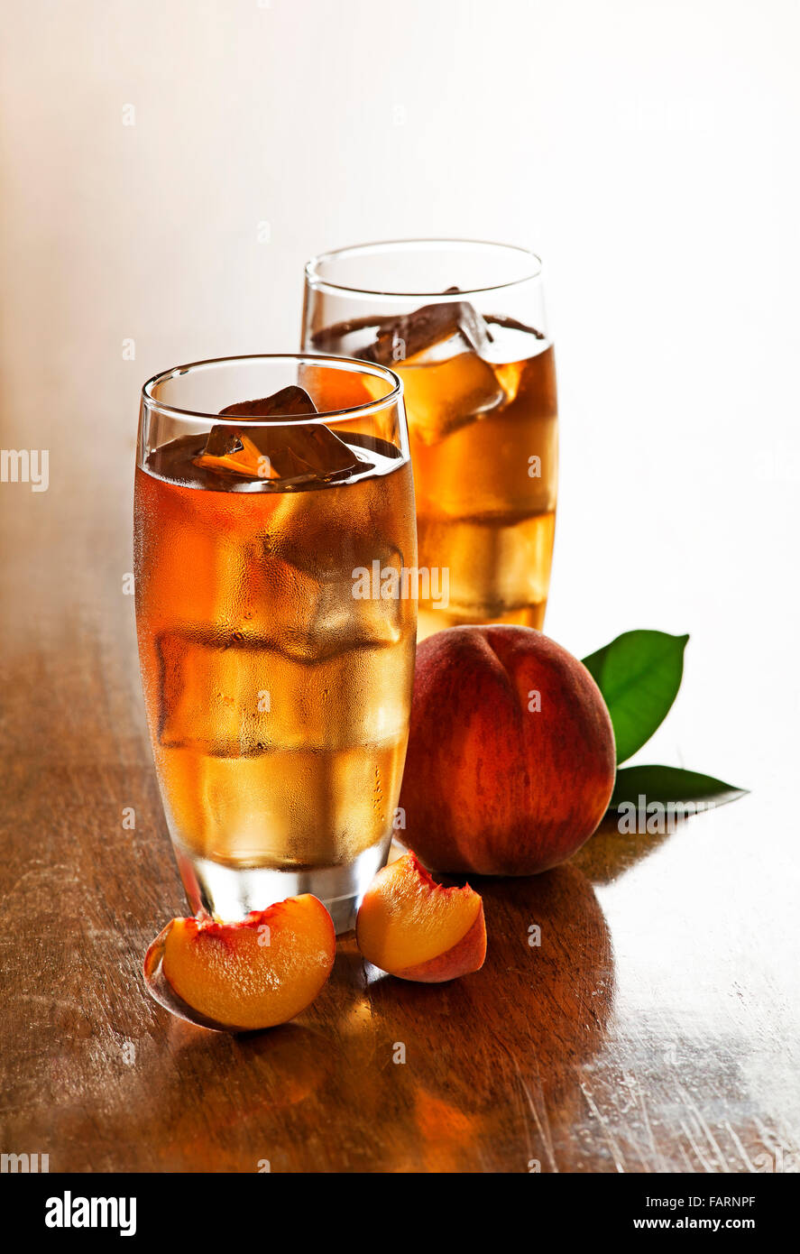 Bicchiere di ghiaccio di pesche tè con fette di cubi. Foto Stock