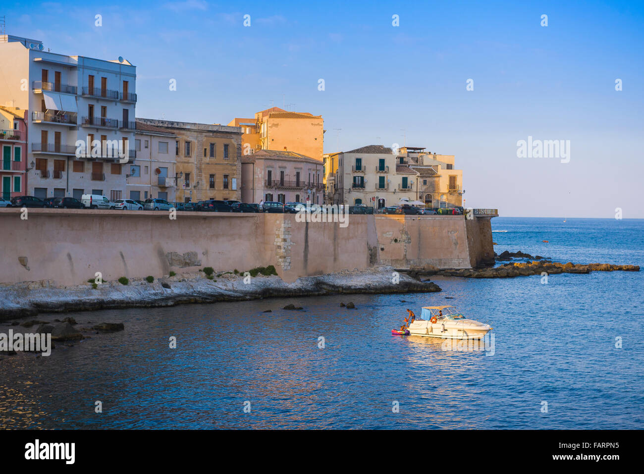 Italia vacanze in famiglia, vista al tramonto in estate di una famiglia italiana relax su una barca per il tempo libero in una insenatura in Ortigia (Siracusa) Sicilia. Foto Stock