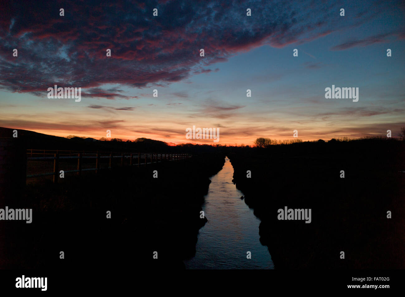 Fiume Dun,Normandia, all'alba, campi scuri, red reflection Foto Stock