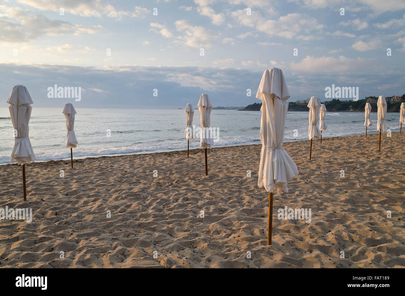 Ombrellone sulla costa deserta del mare di sunrise Foto Stock