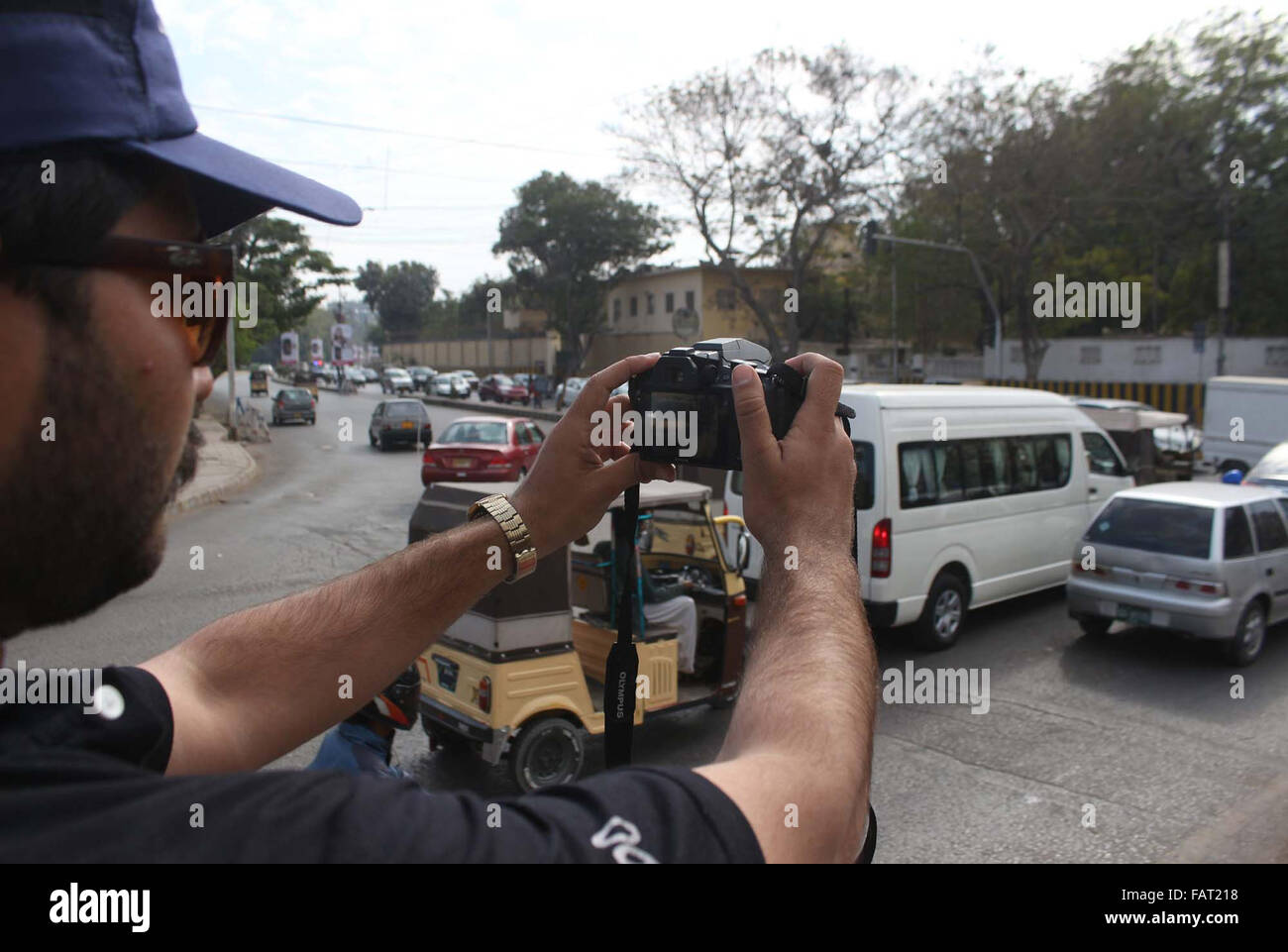 Il personale di polizia fare film di pendolari passando attraverso la strada nelle vicinanze Hotel Metropol a Karachi il lunedì, 04 gennaio 2016. Le autorità di polizia consegnato le fotocamere digitali per il personale per la realizzazione di film di pendolari presunta nel segnale di traffico violazione. Foto Stock