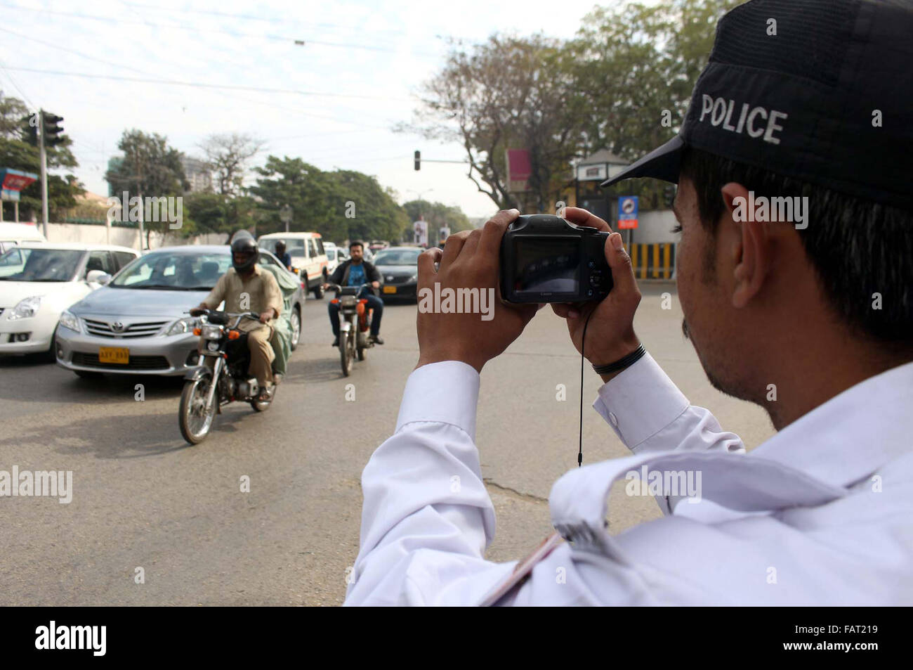 Il personale di polizia fare film di pendolari passando attraverso la strada nelle vicinanze Hotel Metropol a Karachi il lunedì, 04 gennaio 2016. Le autorità di polizia consegnato le fotocamere digitali per il personale per la realizzazione di film di pendolari presunta nel segnale di traffico violazione. Foto Stock