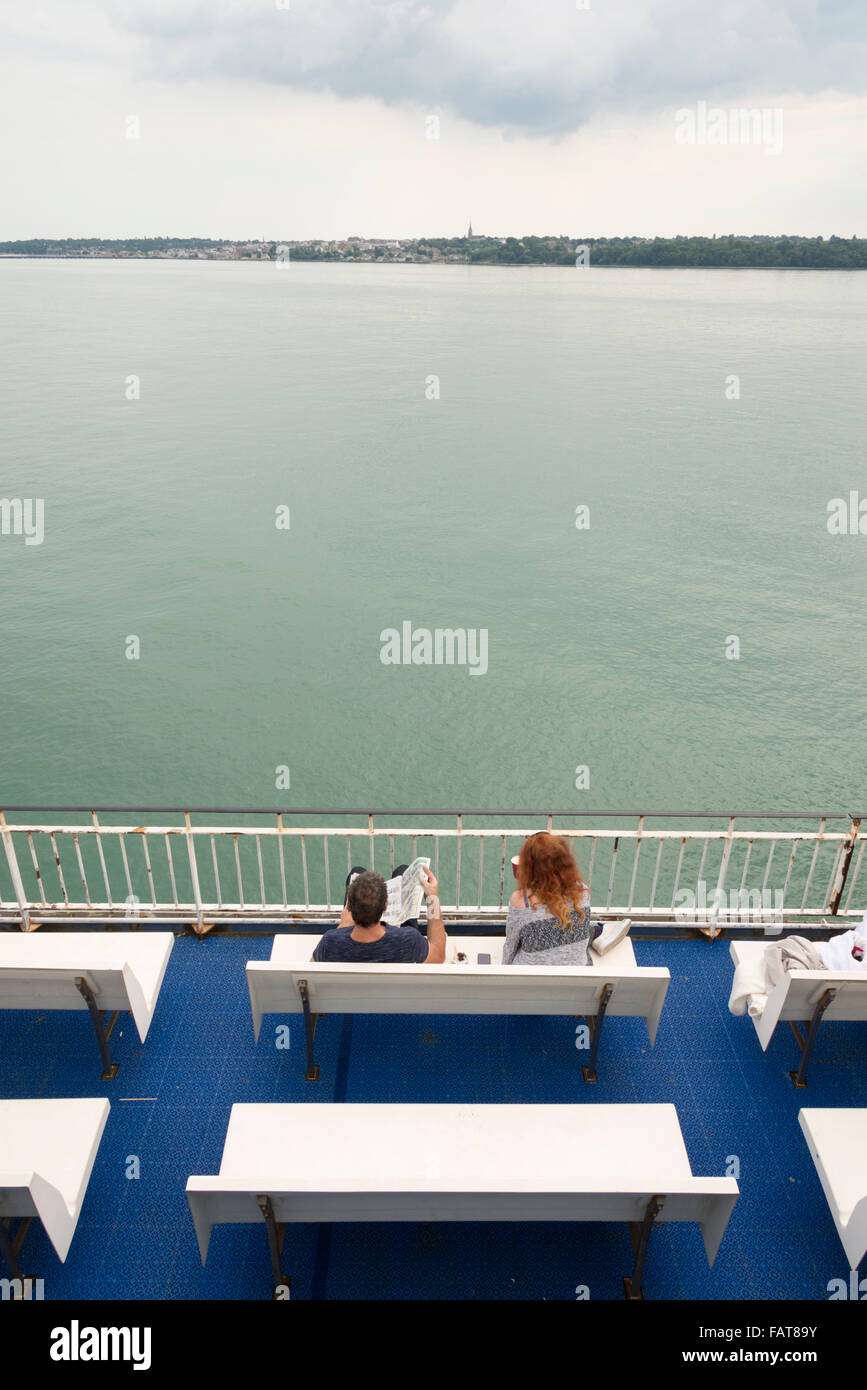 I passeggeri seduti su un sedile rilassante mentre su un traghetto tra l'Isola di Wight e la terraferma britannica Foto Stock