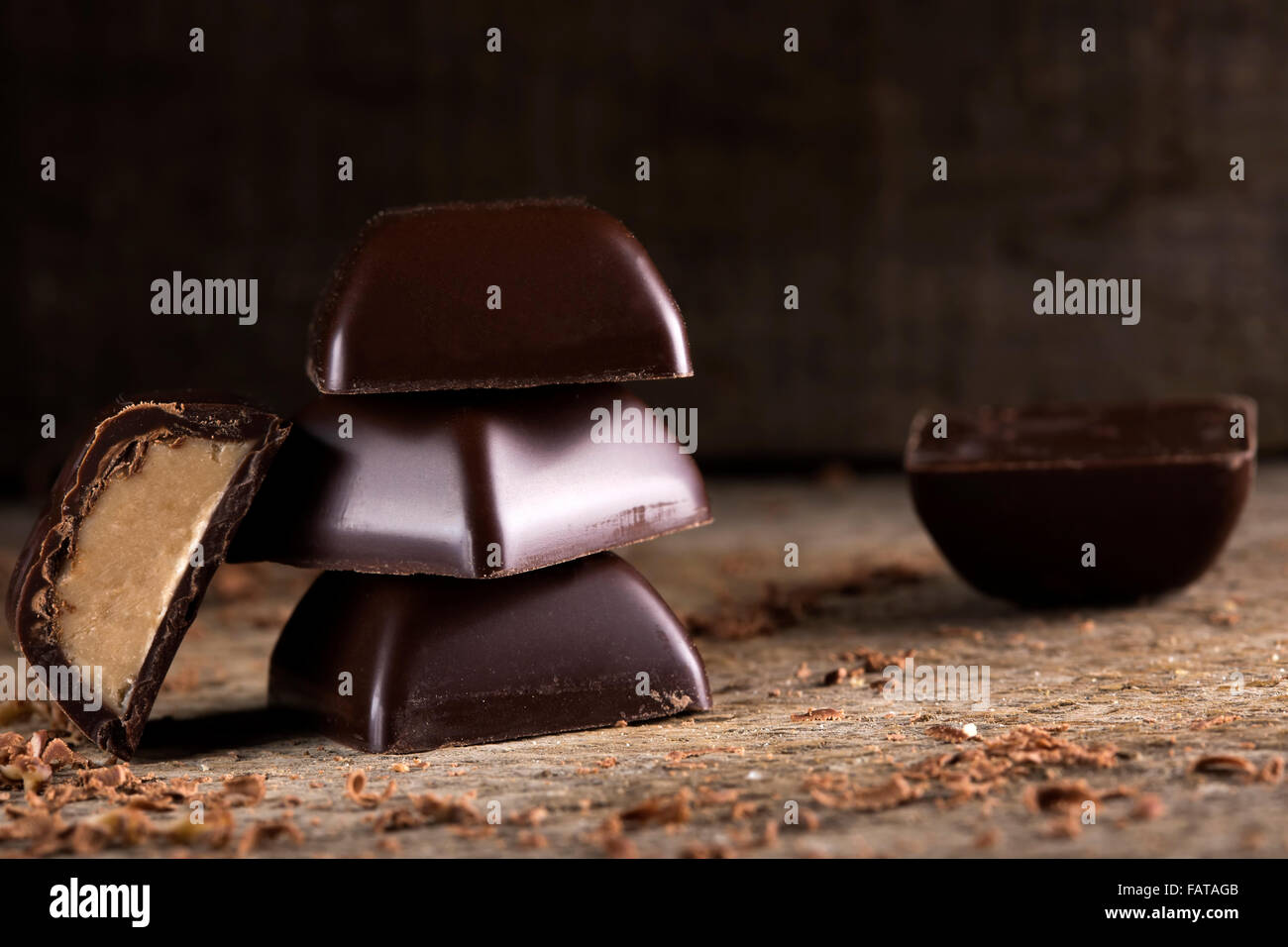 Pila di pezzi di cioccolato su legno sfondo rustico Foto Stock