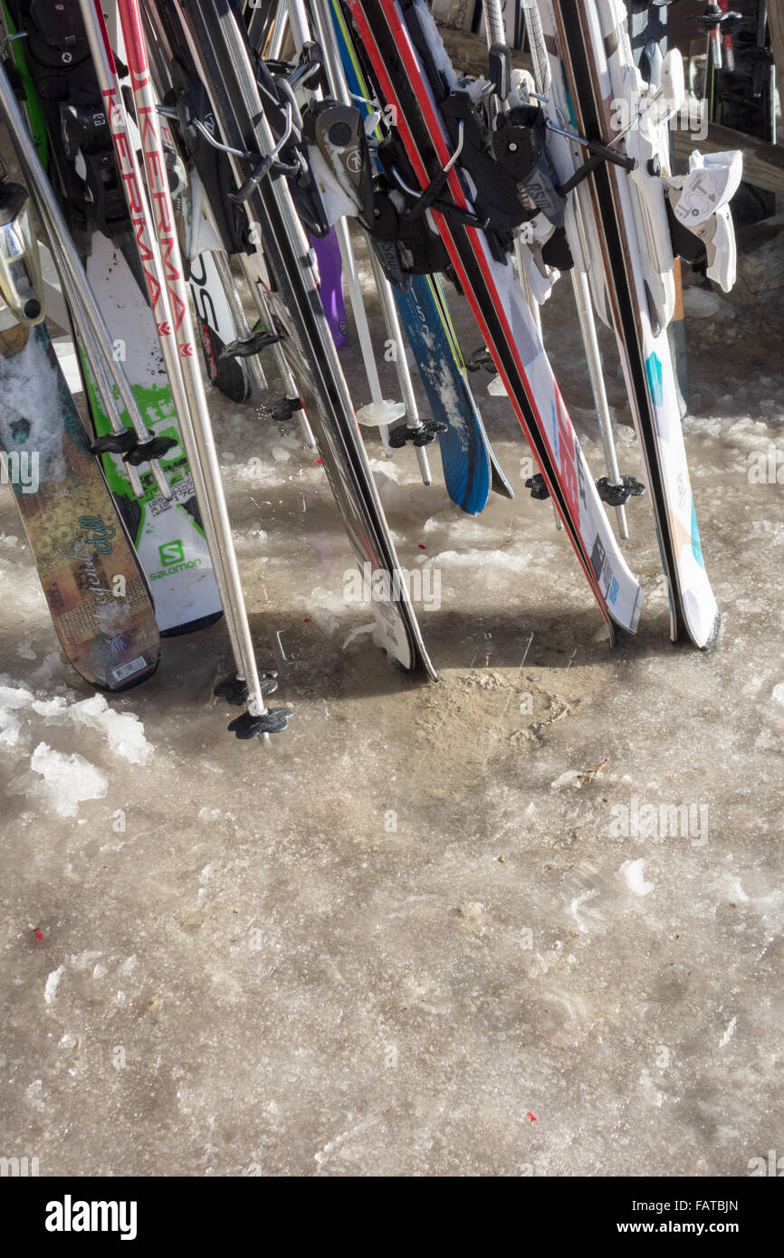 Sci in rack di sci sulla neve di fusione durante unseasonably clima caldo - Courchevel, Francia Foto Stock