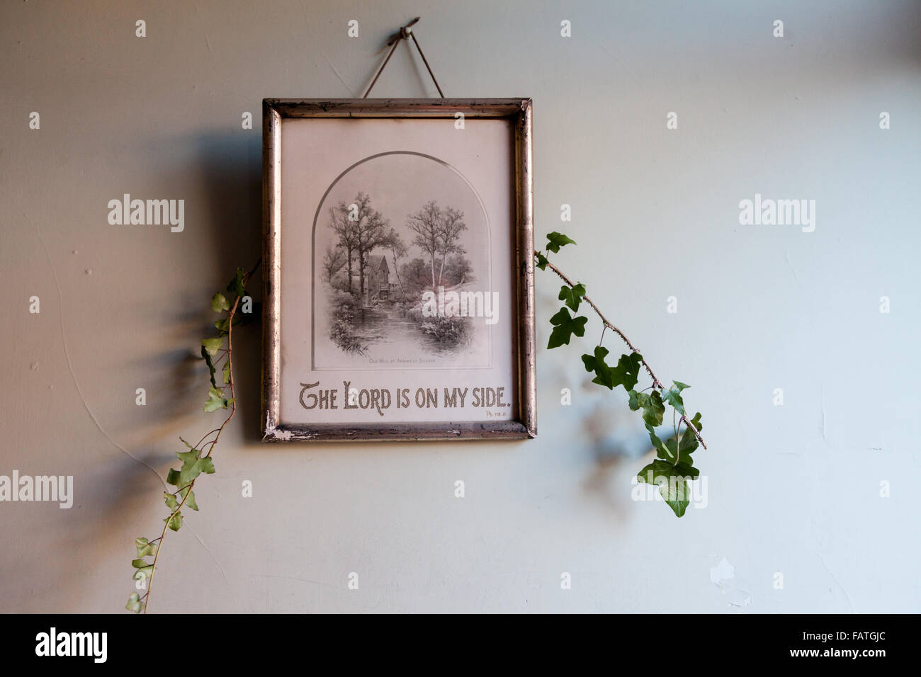 Vecchio vittoriano o Edwardian British picture su una parete con il Signore è il mio lato, ed edera decorazione con parete semplice sfondo. Foto Stock