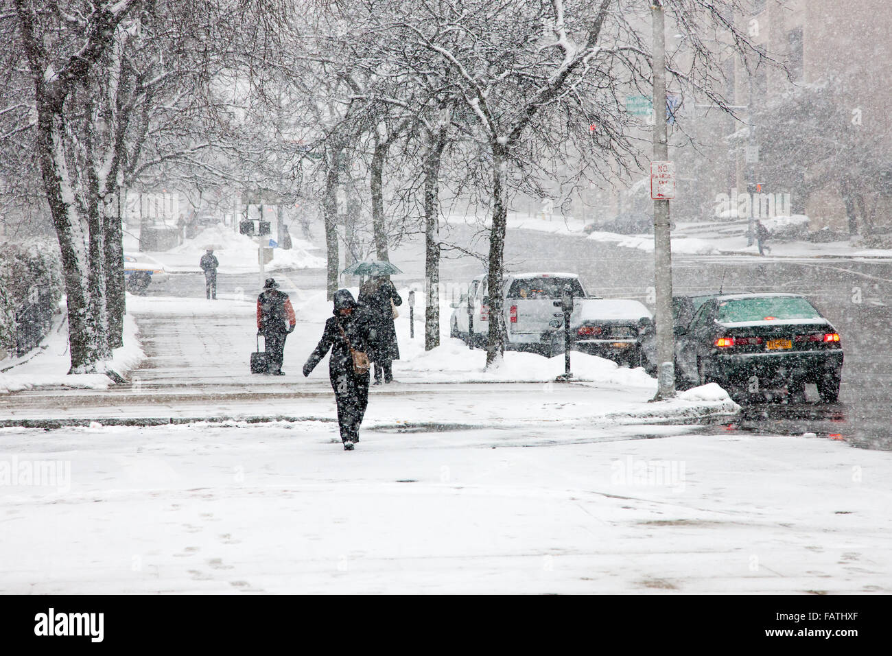 La gente a piedi sui marciapiedi innevati durante una tempesta di neve in White Plains, New York. Foto Stock