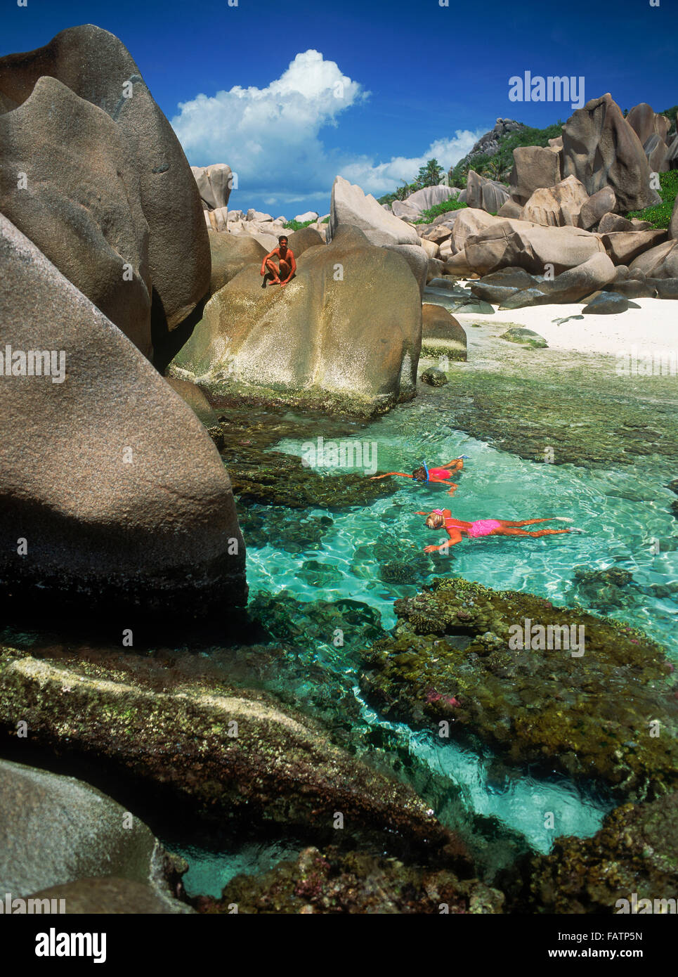 I turisti lo snorkeling in pozze di marea su La Digue Island alle Seychelles Foto Stock
