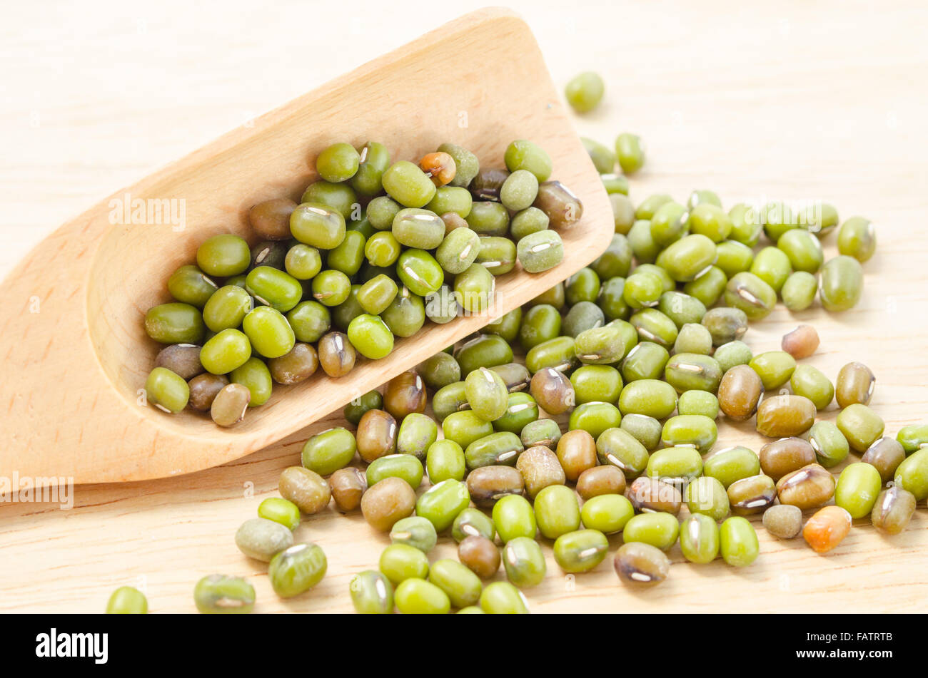 Una sana alimentazione verde materie organiche fagioli mung in cucchiaio di legno. Foto Stock