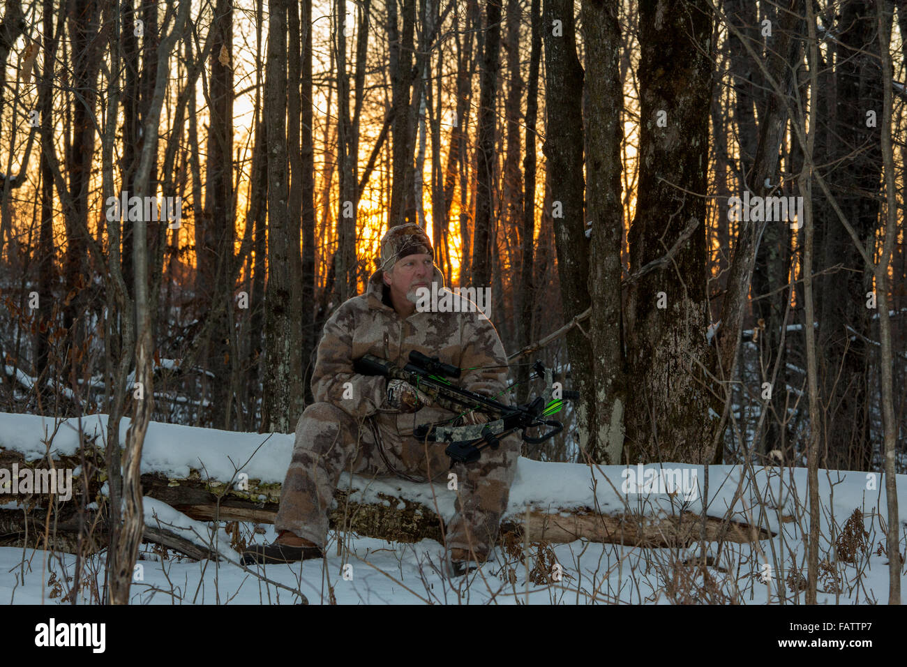 Crossbow hunter seduto su un log Foto Stock