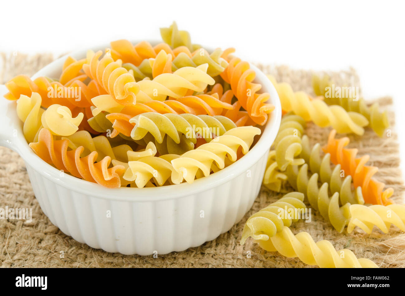 Essiccata la pasta italiana (maccheroni) nella vaschetta di colore bianco su sfondo di sacco. Foto Stock